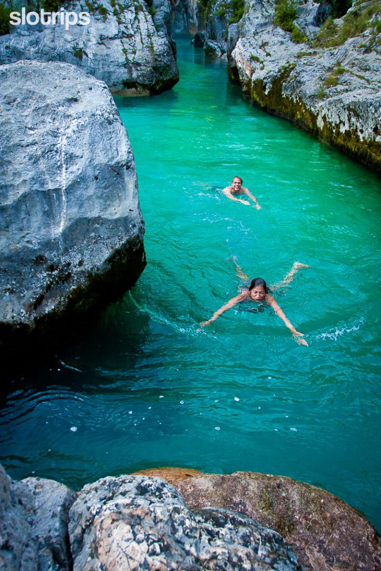 Happy travelers swimming in the Soca river in Slovenia