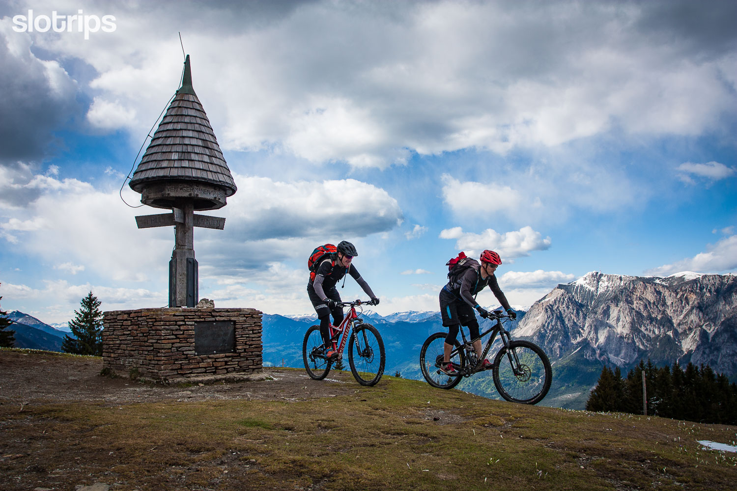 Two mountain bikers on the top of Mt. Tromeja, Triple border, bordering Slovenia, Italy and Austria