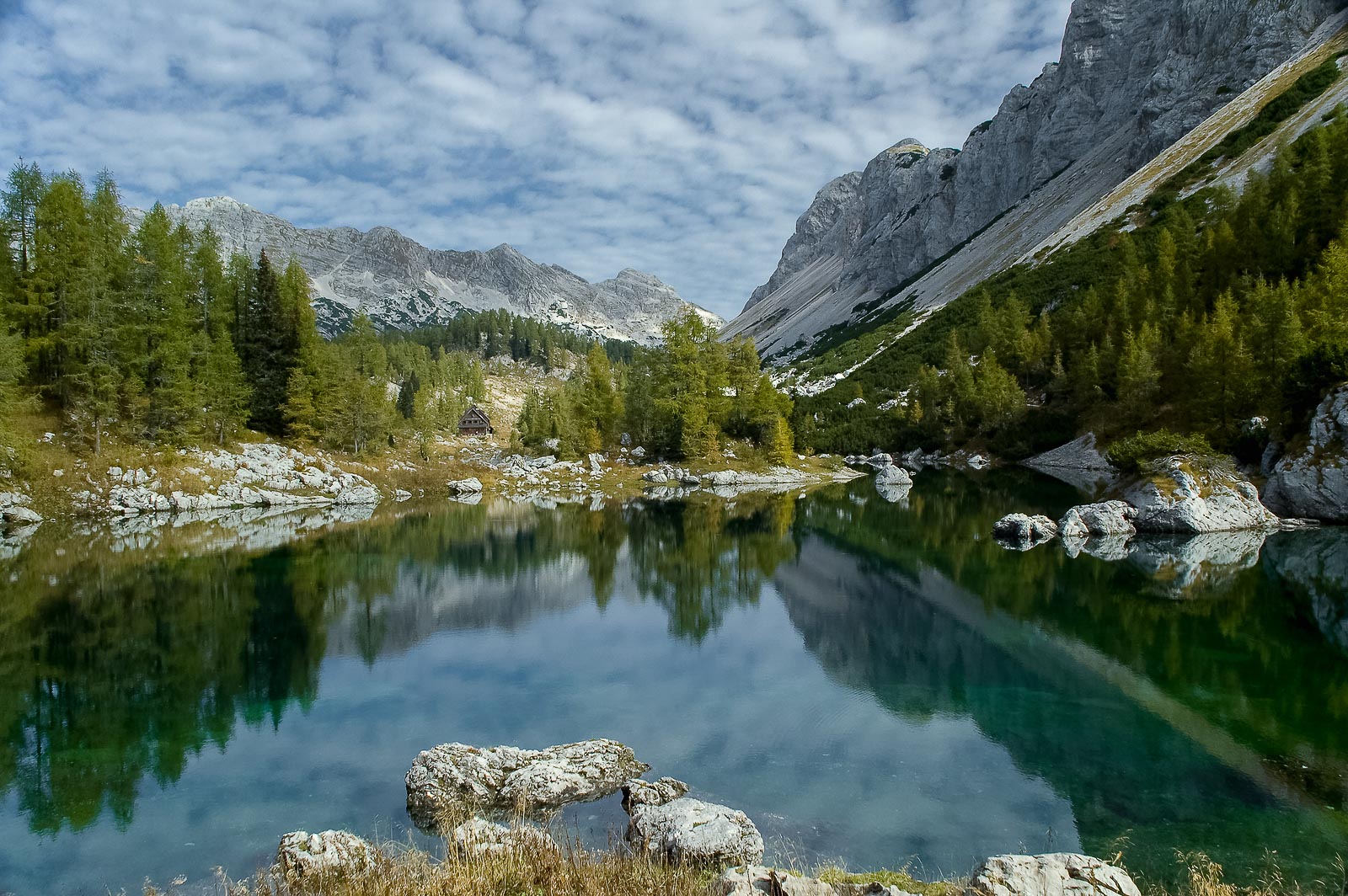 Beautiful deep green Double Lake reflecting mountains and forests above the Seven Triglav Lakes mountain hut.