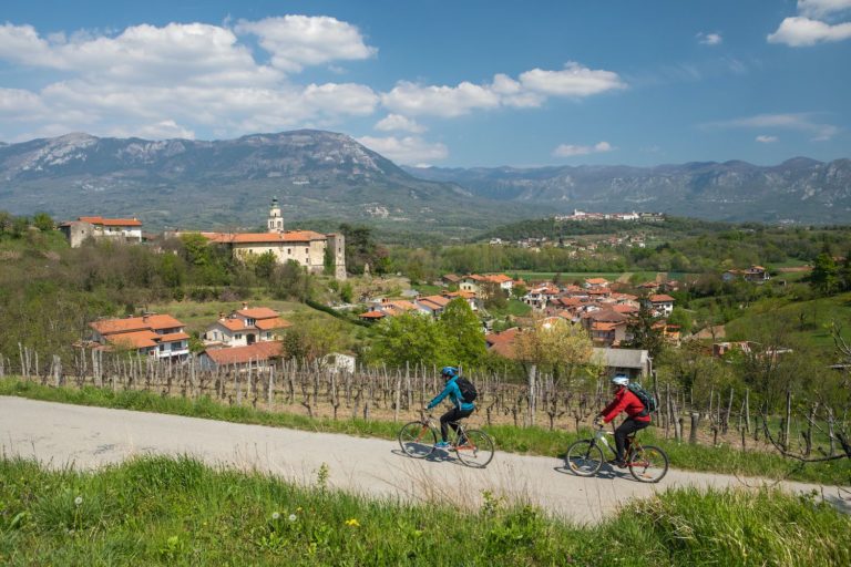 A couple biking through the wine hills in Vipava Valley, Slovenia