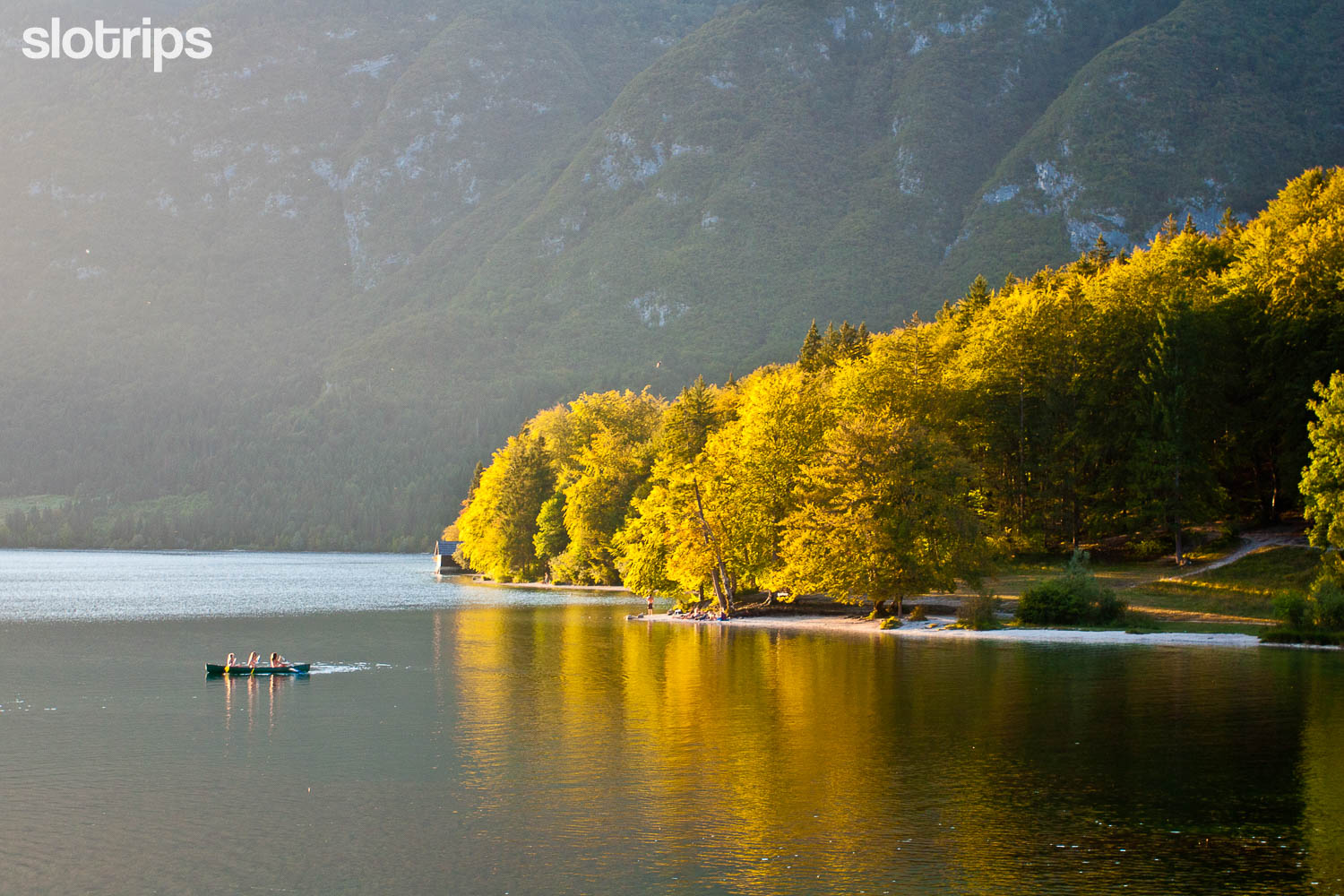 A family on a canoe trip across Lake Bohinj on a sunny autumn day