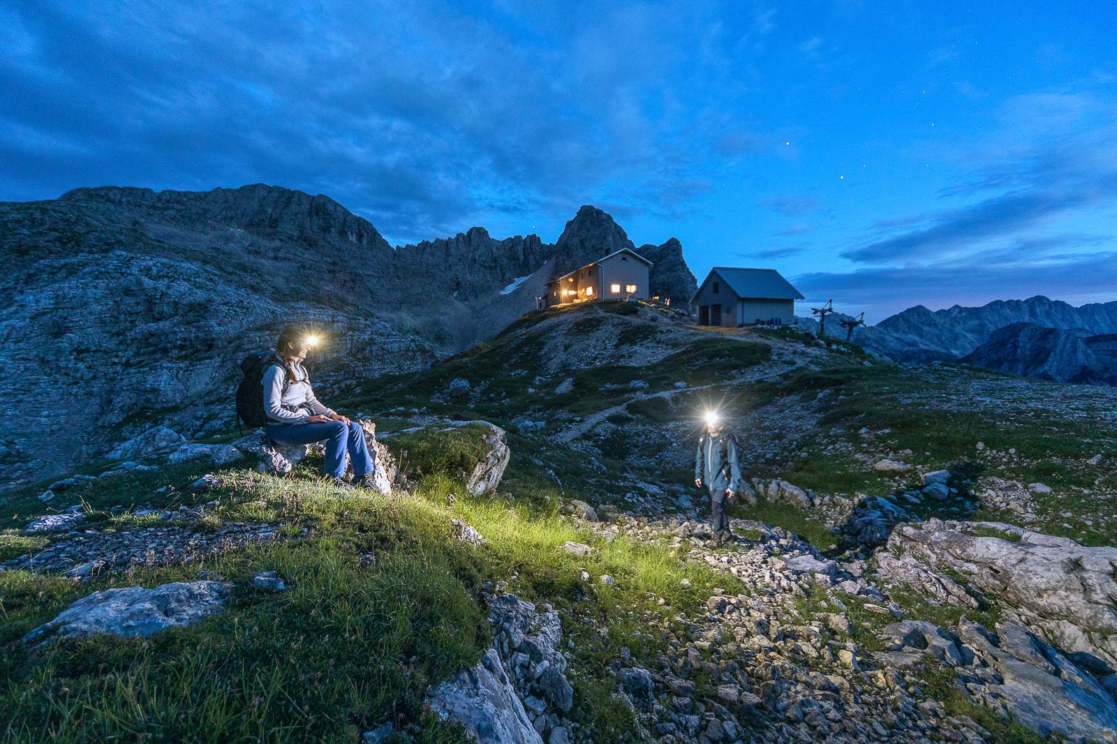 Hikers at Prehodavci mountain hut in the Julian Alps at dusk