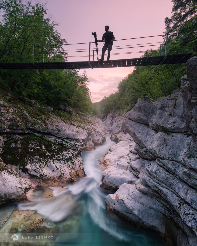 Photographer on a hanging bridge above the Sova river, Slovenia