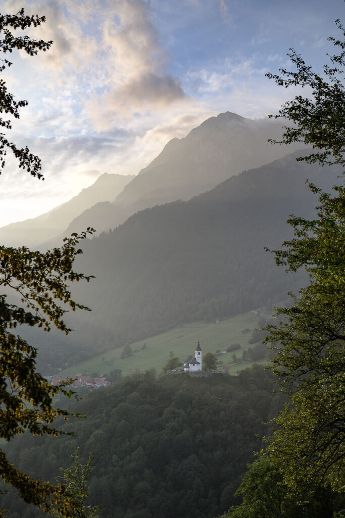 A church on a hill overlooking a village in the Soca Valley in Slovenia
