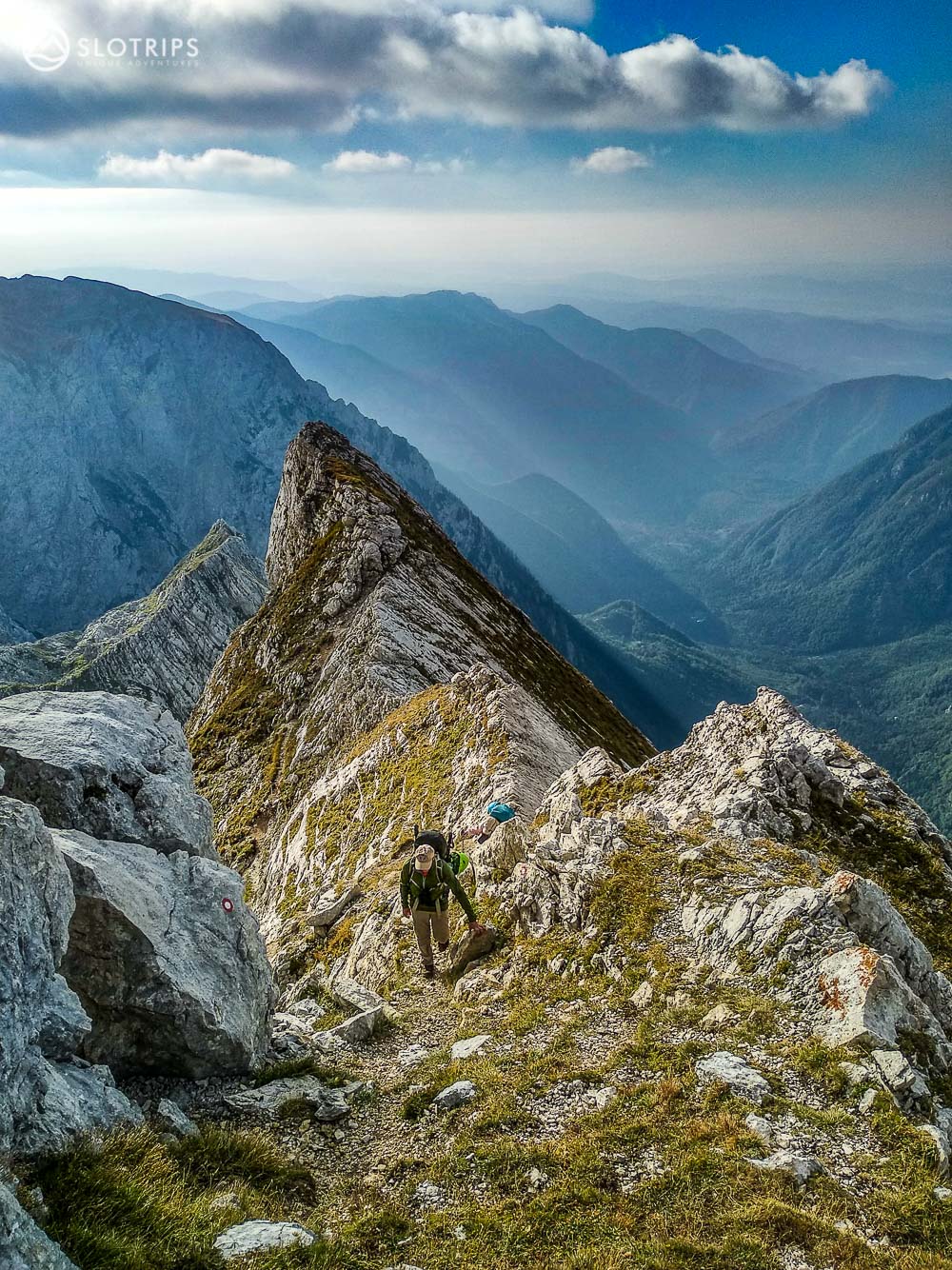 Hiker on a steep slope in Kamnik-Savinja Alps