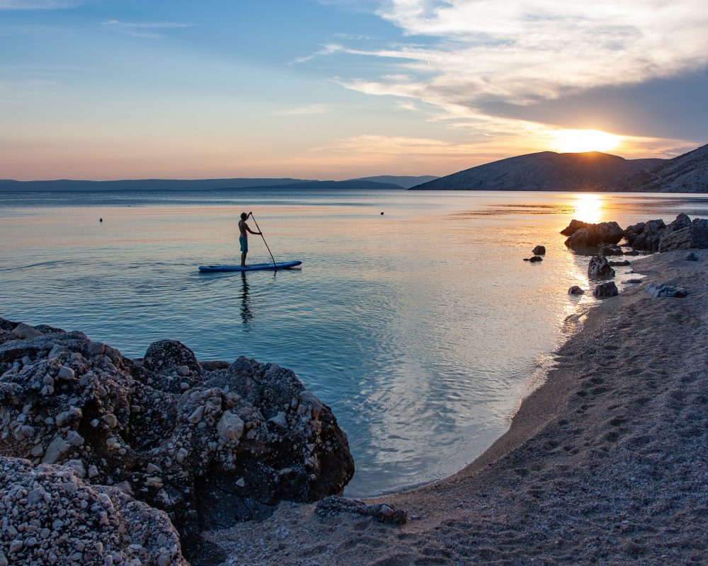 Stand up paddling in Croatia's island of Krk at sunset