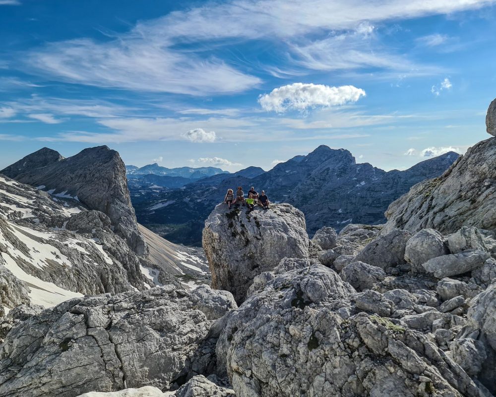 Hiking group on a boulder in the Triglav National Park